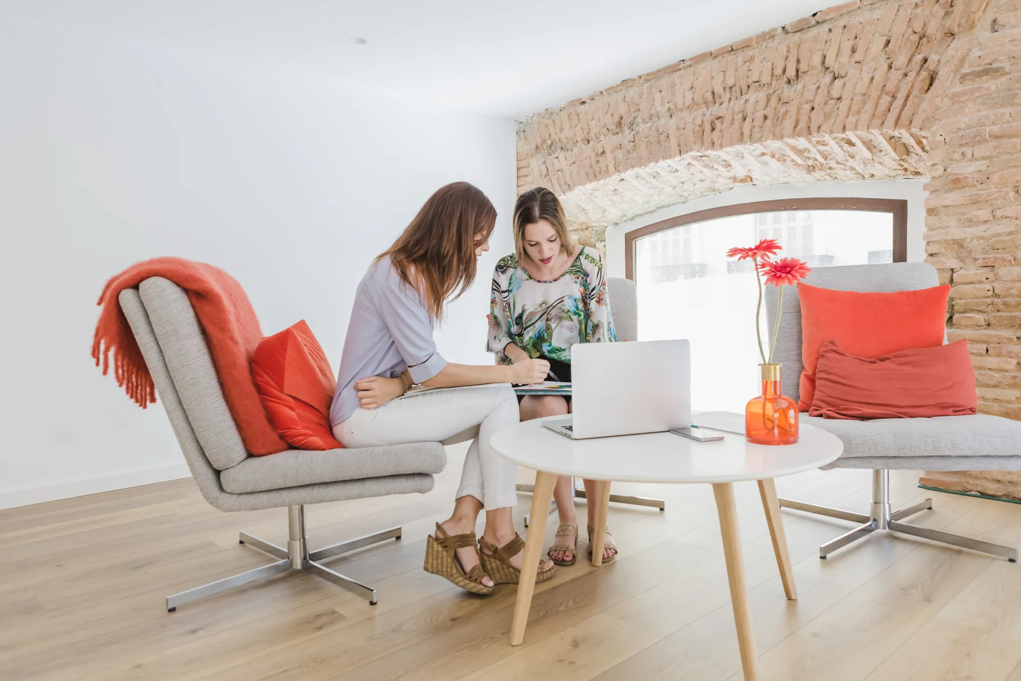 Deux femmes discutant dans un espace de travail lumineux.