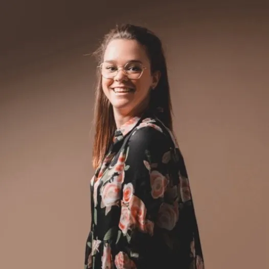 Portrait souriant d’une femme en tenue fleurie.